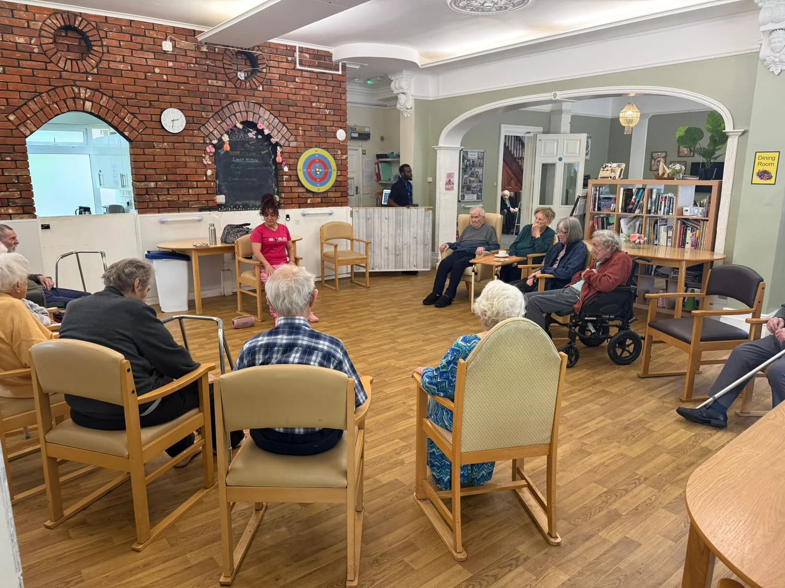 Residents gathered in a lounge for a seated movement activity at Braydeston Court.