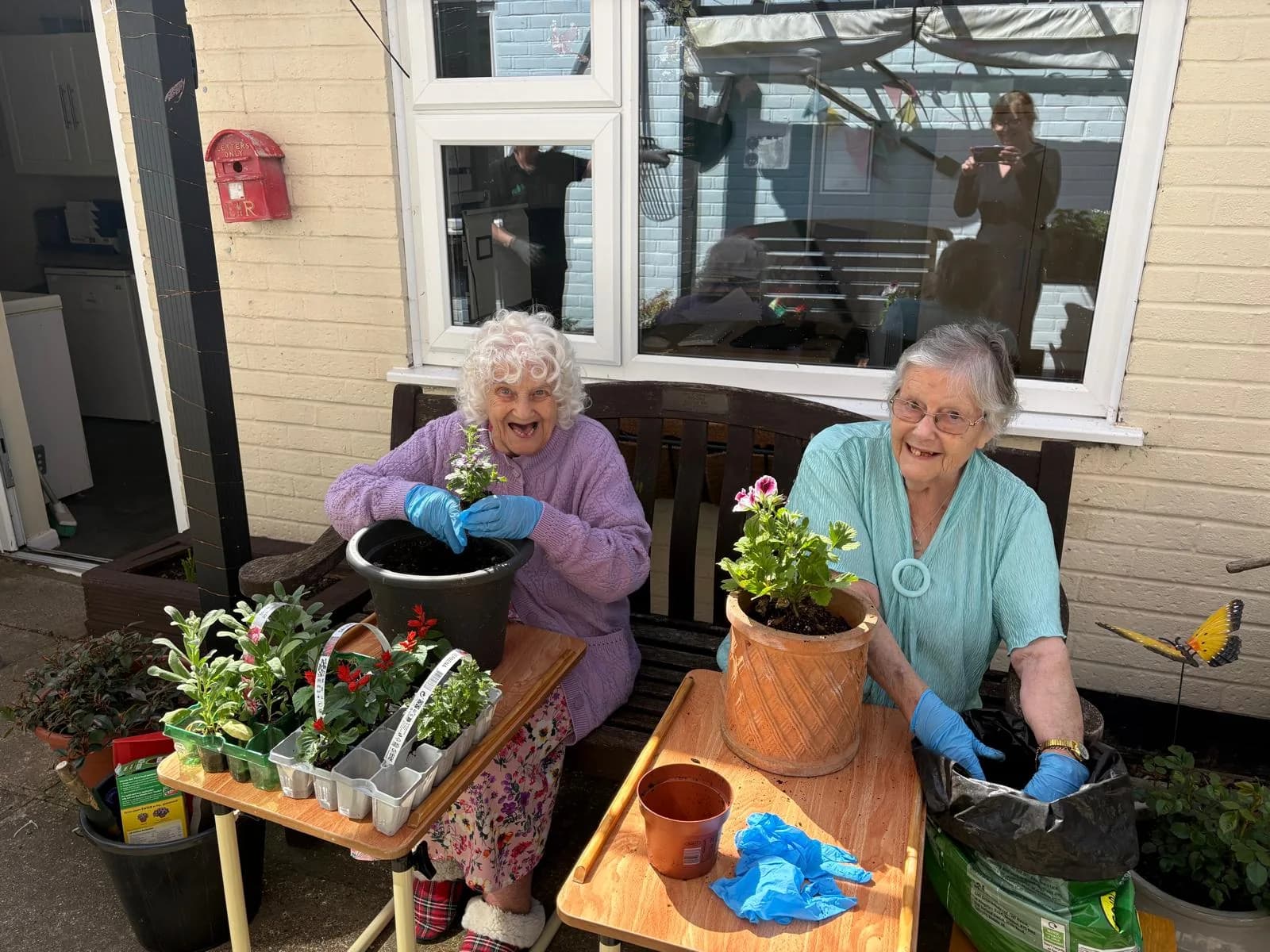 Two residents gardening together outside at Martham Lodge.